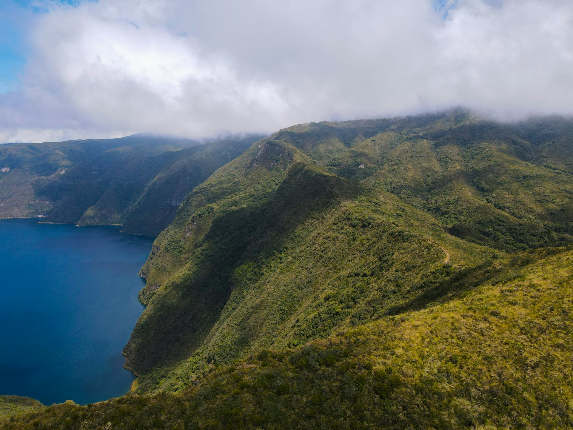 A volcanic crater lake surrounded by green hills