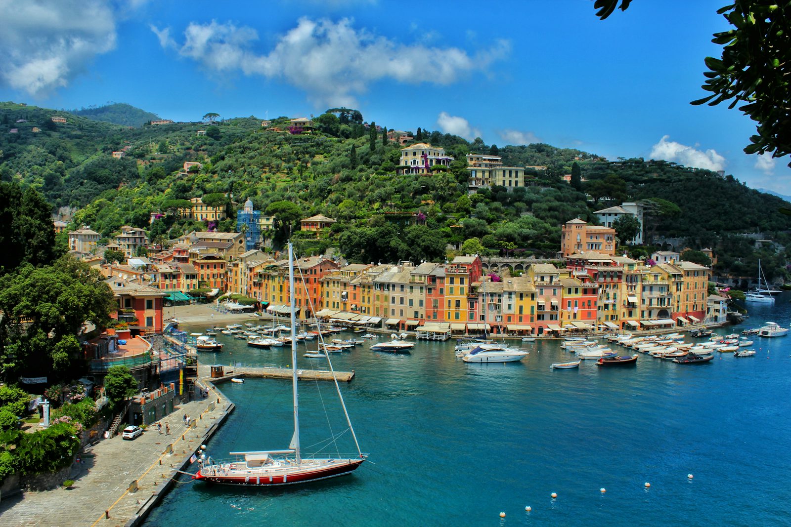 A boat on the water beside a pastel Italian harbor town