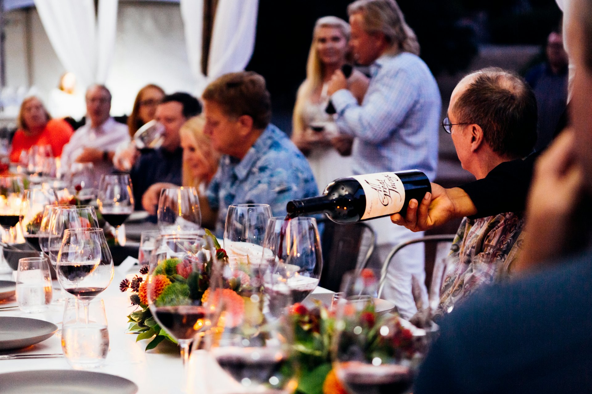 Friends sharing wine around a table at a winery